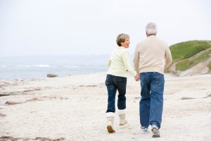 Couple at the beach holding hands and smiling